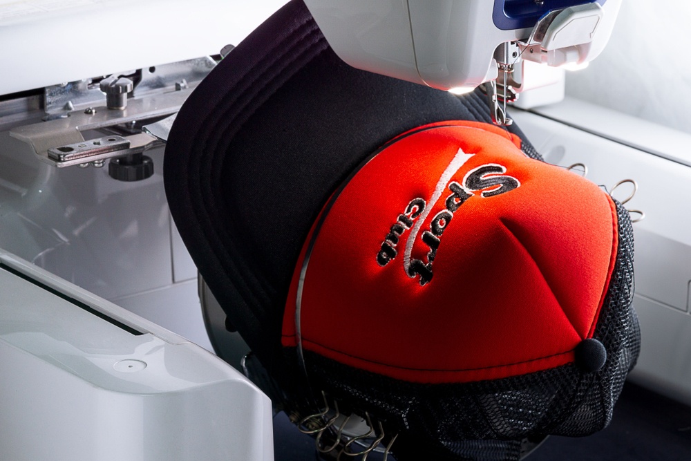 red sport cap on the hoop of embroidery machine