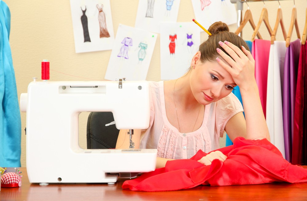 young dressmaker in stress during sewing the clothes